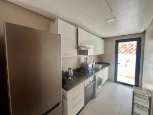 a kitchen with a refrigerator and a stove top oven at Zen & Welcoming CFC - Garage & Tramway in Casablanca
