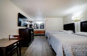a hotel room with two beds and a desk at Canaan Motel in Canaan +7 photos