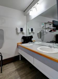 a bathroom with two sinks and a large mirror at Canaan Motel in Canaan