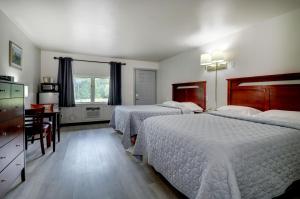 a hotel room with two beds and a desk at Canaan Motel in Canaan