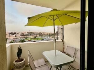 a table with a yellow umbrella on a balcony at Sweet Jacob's City Center in Agadir
