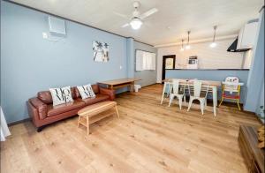 una sala de estar con un sofá y una mesa en Osaka 365B&B, en Osaka