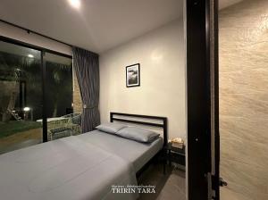 a bedroom with a bed and a large window at ธีริน ธารา - ที่พักริมแม่น้ำแควใหญ่ (TRIRIN TARA) in Ban Tha Pong (1)