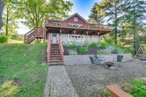 ein Haus mit einer Terrasse und einer Treppe im Hof in der Unterkunft Charming Wolcott Cottage with Fire Pit and Mini Dock in Wolcott