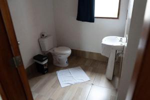 une petite salle de bain avec toilettes et lavabo dans l'établissement Galapagos Morning Glory, à Puerto Ayora