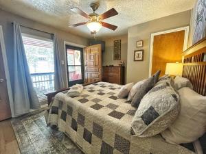 una camera da letto con un letto e un ventilatore a soffitto di Valley Condo 106 - Creekside - WiFi - Hot Tub - Fireplace - Washer - Dryer - Playground a Red River