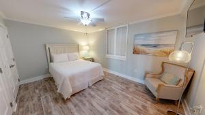 Un dormitorio con una cama y una silla dentro. en Dolphin Point 105B- by Holiday Isle Properties, en Destin