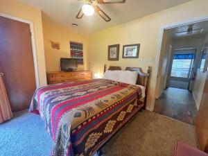 una camera da letto con un letto e una televisione di Valley Condo 107 - Creekside - WiFi - Hot Tub - Fireplace - Washer - Dryer - Playground a Red River Altre 11 foto