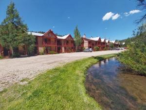 una casa con un laghetto davanti di Valley Condo 109 - Chili Peppers - Creekside - WiFi - Hot Tub - Fireplace - Washer - Dryer - Playground a Red River