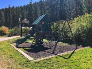 un parco giochi con uno scivolo in un parco di Valley Condo 109 - Chili Peppers - Creekside - WiFi - Hot Tub - Fireplace - Washer - Dryer - Playground a Red River