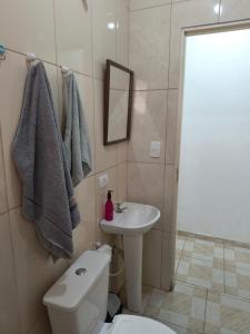 a bathroom with a white toilet and a sink at Apartamento aconchegante em Santana de Parnaíba SP in Santana de Parnaíba