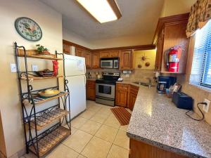 una cucina con frigorifero bianco e armadietti in legno di Valley Condo 110 - Creekside - WiFi - Pet Friendly - Hot Tub - Fireplace - Washer - Dryer - Playground a Red River