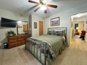 una camera da letto con un letto e un ventilatore a soffitto di Valley Condo 112 - Creekside - WiFi - Pet Friendly - Hot Tub - Fireplace - Washer - Dryer - Playground a Red River