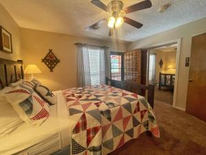 una camera da letto con un letto e un ventilatore a soffitto di Valley Condo 116 - Creekside - WiFi - Hot Tub - Fireplace - Washer - Dryer - Playground a Red River Altre 10 foto