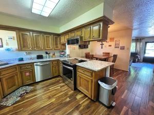 una cucina con mobili in legno e un piano di lavoro di Valley Condo 117 - Creekside - WiFi - Hot Tub - Fireplace - Washer - Dryer - Playground a Red River