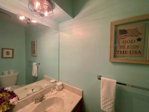 un bagno con lavandino e specchio di Valley Condo 117 - Creekside - WiFi - Hot Tub - Fireplace - Washer - Dryer - Playground a Red River