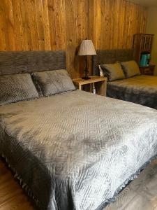 a bedroom with a large bed and a table with a lamp at ParkWay Yellowstone Guest House Room #1 in Gardiner