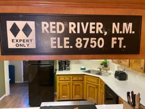 un cartello sul muro di una cucina di Valley Condo 119 - Creekside - WiFi - Hot Tub - Fireplace - Washer - Dryer - Playground a Red River