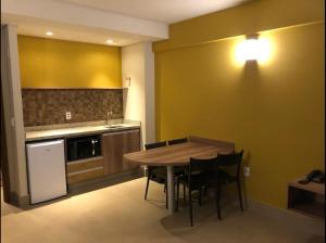 una cucina con tavolo e sedie in legno di Hotel Resort Próximo ao Parque Thermas a Olímpia