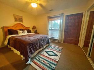 una camera con letto, finestra e tappeto di Valley Condo 124 - Creekside - WiFi - Hot Tub - Fireplace - Washer - Dryer - Playground a Red River