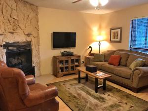 un soggiorno con divano e camino di Valley Condo 126 - Creekside - WiFi - Hot Tub - Fireplace - Washer - Dryer - Playground a Red River