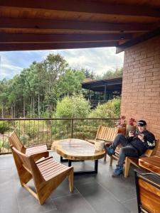 a man sitting on a chair on a patio at Cabaña Colorata Residencial in Atemajac de Brizuela +24 photos