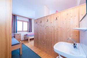 Łazienka z drewnianą ścianą i umywalką w obiekcie Berggasthof Biberg w mieście Saalfelden am Steinernen Meer