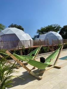 a person laying in a hammock on a beach at Hotel Aqua House in Tubará