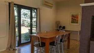 a dining room with a wooden table and chairs at Whispering Moon Cottage in Orange