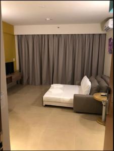 una camera da letto con un letto bianco e un divano di Hotel Resort Próximo ao Parque Thermas a Olímpia