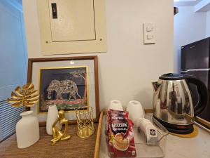 a kitchen counter with a coffee pot and a picture at Verdon Parc 2 Bedroom Unit with Big Balcony in Davao City