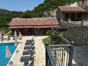 a resort with a pool and chairs and a building at Eco Villas Merak in Virpazar