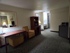 a room with a desk and a table and a chair at Olympia Inn in Colorado Springs