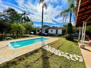 a swimming pool in a yard next to a house at Chácara Milk & Shake in Cotia