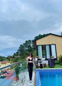 a woman walking next to a swimming pool at Bich Ngoc Villa - Venuestay in Tam Ðảo