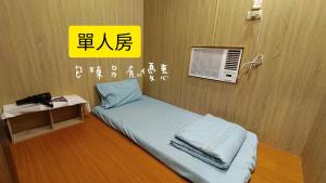a bed in a room with a yellow sign at 綠島包棟 Beer Inn in Green Island