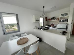 a kitchen with a white counter and a table at Torres al Mar in Monte Hermoso