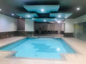 マニラにあるCylo's Place Spacious 2BR Apt linked to MRT Station near GMA 7の青い天井の大型屋内スイミングプール