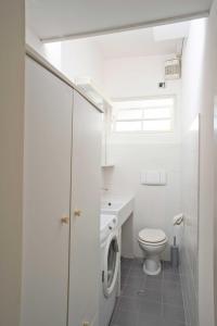 a bathroom with a toilet and a sink and a window at Casa Lorenza in Albisola Superiore