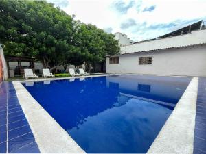 a swimming pool with blue water in front of a building at Sunset Taganga Hotel in Taganga