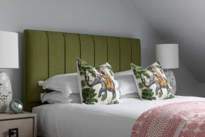 a bed with a green headboard and pillows on it at The Broughton Townhouse in Edinburgh