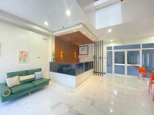 a living room with a green couch and a kitchen at Asia Jem Hotel - BAYAWAN in Bayawan