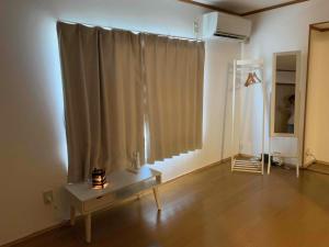 a living room with a table in front of a window at あまみ日和 奄美大島の宿 -Amami Biyori- in Amami
