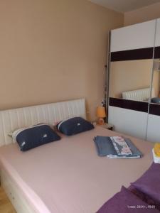 a bed with two blue pillows and a mirror at Messembria Palace Bulgaria in Sunny Beach