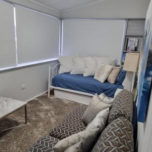 une chambre avec deux lits et un canapé dans l'établissement Brisbane waters cottage at Point Clare NSW, à Point Clare