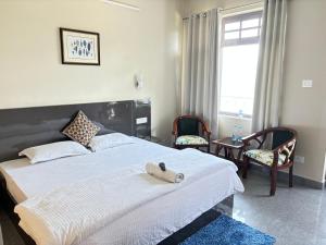 ein Schlafzimmer mit einem Bett, auf dem ein Stofftier liegt in der Unterkunft FORTUNE HEIGHTS DALHOUSiE in Dalhousie