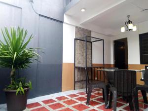 a room with a table and chairs and a plant at Jil's Apartelle in Tagaytay