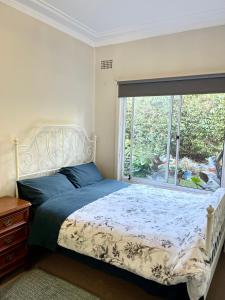 a bedroom with a bed and a large window at Tranquil Garden view Room Macquiare Marsfield Eastwood in Sydney