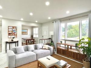 a living room with a couch and a large window at New 3 Bedroom Bungalow Ground Floor with BBQ Patio in Richmond Hill