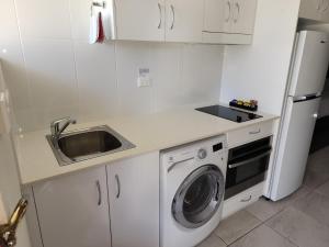 a kitchen with a sink and a washing machine at Superior Studio 20 Endeavour Inn in Emu Park +7 photos